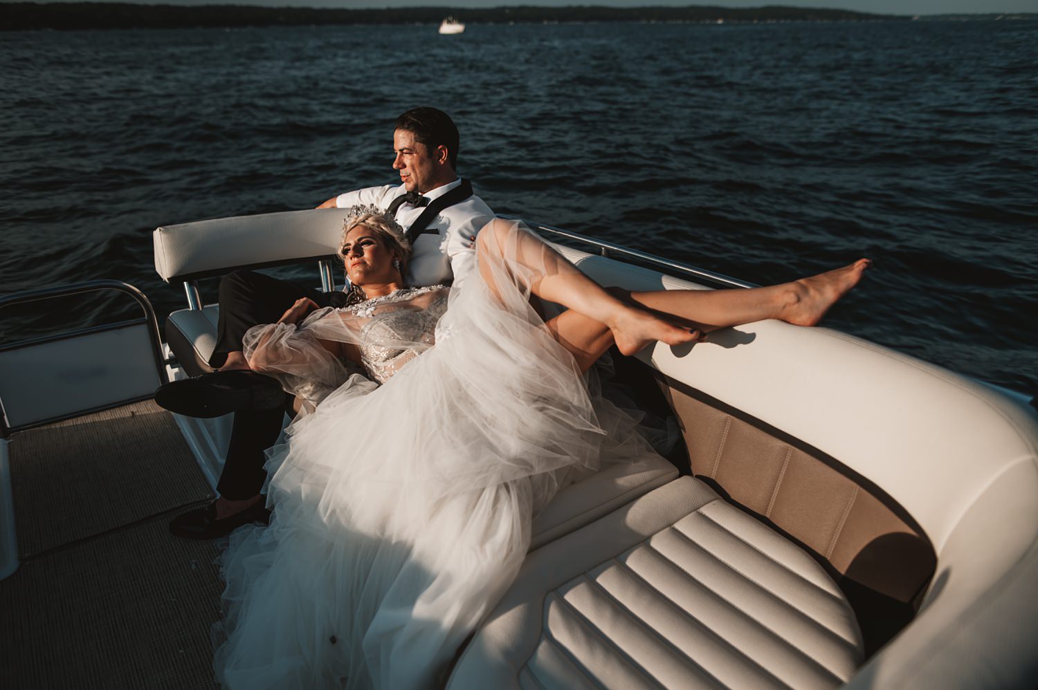 Lake Geneva Micro Wedding - The Adamkovi bride and groom photos on a boat bride lying, long legs