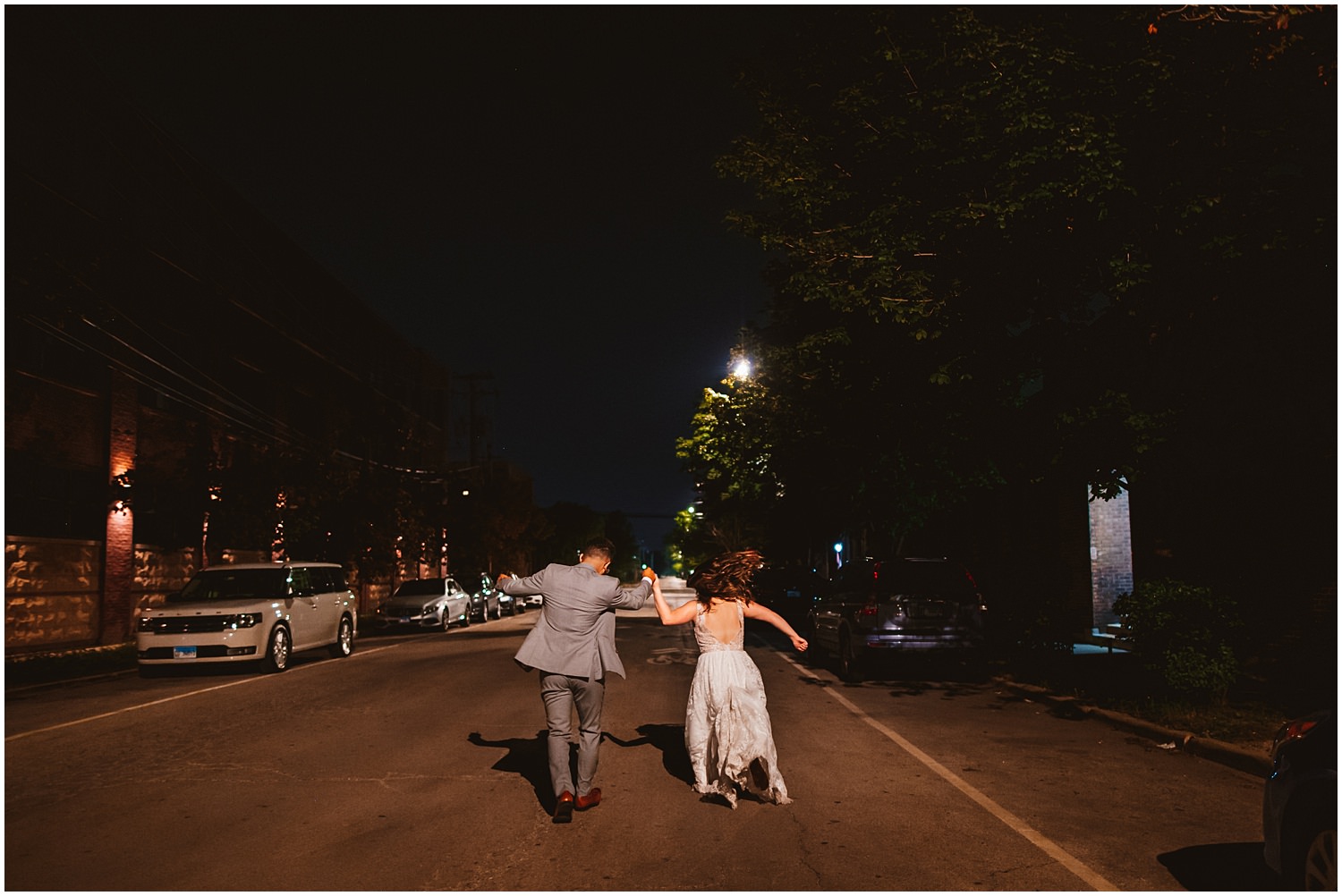 Salvage One documentary Wedding Photography - Night sparkler send off couple running in the middle of street