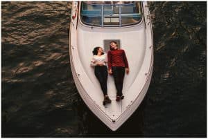 engagement photo of a couple lying on a boat in the middle of Chicago river. photo is from way above them so the boat is nearly all in frame